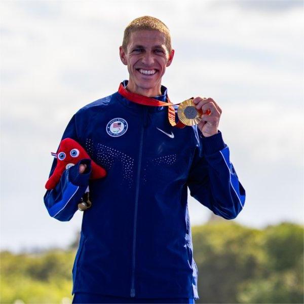 Chris Hammer poses for a photo with his gold medal after winning his Para Triathlon event at the 2024 Paris Paralympic Games.